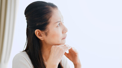 家で悩むシニア女性