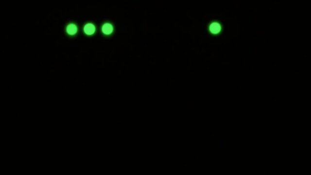 Wi-Fi router or modem light blinking. Wireless internet connection. Flashing green warning lights in black darkness. The process of transferring information through modern means of communication.