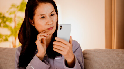 スマートフォンを使うシニア女性