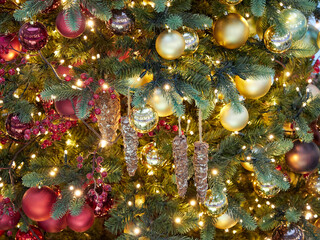 many bright multi-colored Christmas toys on the tree as a wonderful festive background