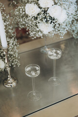 Luxury wedding decor on a table in a restaurant with carnation flowers, gypsophila flowers and candles on candlesticks