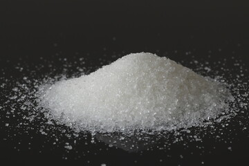 White sugar on a black background. Sugar is made from sugar beets. 