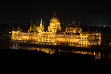 Fototapeta na wymiar The iconique Budapest parlement in Hungary, the biggest building in Europe during the night shining. This is a rare view of the Parlament