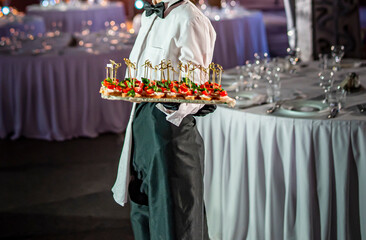 waiter holds tray with canape. Restaurant service. buffet or catering.