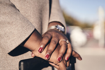 detail of a businesswoman's hands in the suitcase waiting for a vehicle on the road