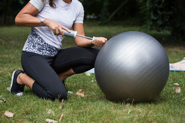 Fitness instructor inflating a rubber gym ball