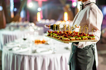 waitress holds tray with canape. Restaurant service. buffet or catering.