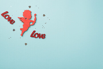 Top view photo of saint valentine's day decorations heart shaped confetti sequins inscriptions love and red cupid silhouette on isolated pastel blue background with blank space