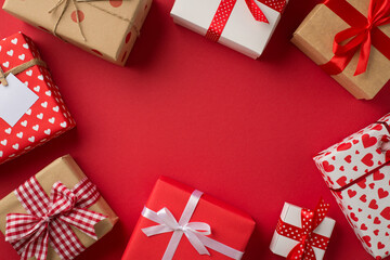 Obraz premium Top view photo of saint valentine's day decorations different gift boxes on isolated red background with copyspace in the middle