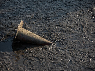 Fototapeta na wymiar River Dumping at low tide revealing old traffic cone at Cook river, Sydney, Australia.
