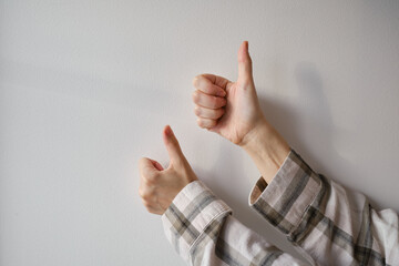 Female hand showing thumbs up gesture showing ok or Excellent on light background. Gestures. Emotions