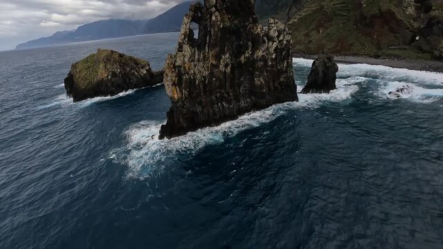 FPV racing drone Mountain surfing, and cliff diving along the rocks. Epic mountain landscape and ocean on Madeira island in Portugal. Beautifull nature.