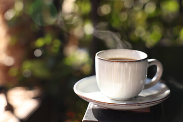 Cup of hot aromatic coffee on table in outdoor cafe. Space for text