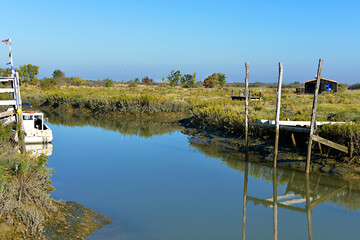 Obraz premium Boat with reflections in the river at Mornac-sur-Seudre, a commune in the Charente-Maritime department in southwestern France 