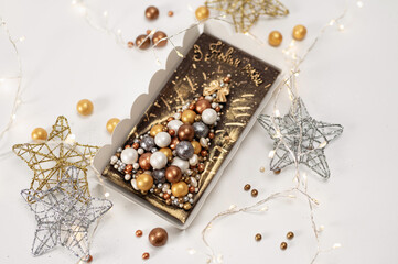 Christmas chocolate card with a Christmas tree made of sweet balls, on a white background with stars and a garland, the inscription in Ukrainian, Happy New Year greetings