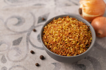 Bulgur with noodles and onions, garnish, on a gray background with a pattern, close up