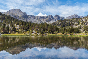 Fototapeta na wymiar Reflections at the lake in the high mountains. (Circ de Pessons, Andorra, Pyrenees Mountains)