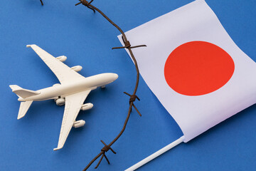 Toy plane, flag and barbed wire on colored background, Japan air border violation concept