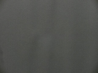 横長で暗い灰色の緩やかな皴のある合成レザーのテクスチャー。柔らかい印象の背景素材。