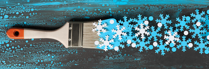 Panoramic winter Christmas banner with painting brush loaded with white blue paper snowflakes.