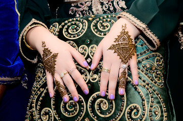 Moroccan bride puts henna on her hands. Moroccan wedding