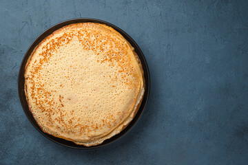 Fried pancakes on a dark gray-blue background.