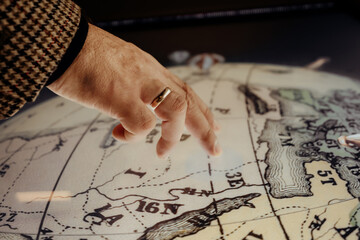 Male hand tapping on globe. Our planet, world map, geography education concept. Modern technology.