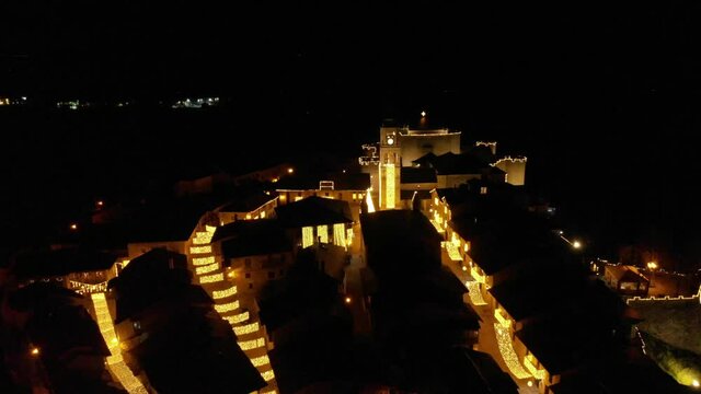 Night aerial view of the beautiful medieval city of Puebla de Sanabria in Christmas season, showing the streets that arrive to the Plaza Mayor and the town bell of the Iglesia Santa Mar&iacute;a del Azogue