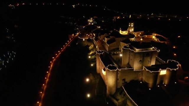 Night aerial view of the beautiful medieval city of Puebla de Sanabria in Christmas season; view of the north side of the Castillo de los Condes de Benavente and the Plaza mayor