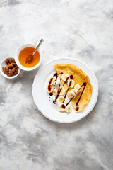 Crepes with banana slice and chocolate sauce top view food