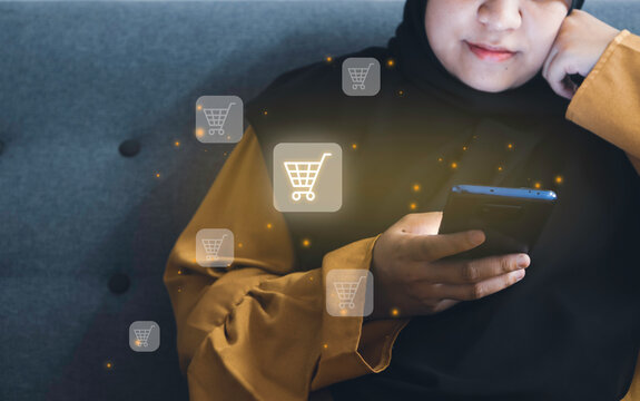 Online shopping concept. Hijabi women add to cart of a product through a mobile phone.