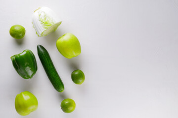 Different green vegetables and fruits on a white background. Healthy food concept. Top view. Copy space