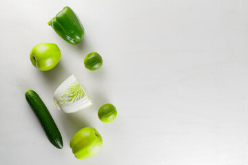 Different green vegetables and fruits on a white background. Healthy food concept. Top view. Copy space