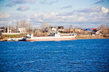 Fototapeta premium close-up river panorama with a cargo ship in the background 