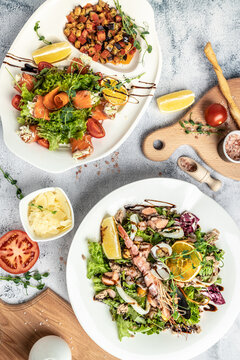 seafood salad Prawn salad. healthy salad of shrimp, mixed greens. fresh salmon rolls with cheese and vegetables. vertical image. top view