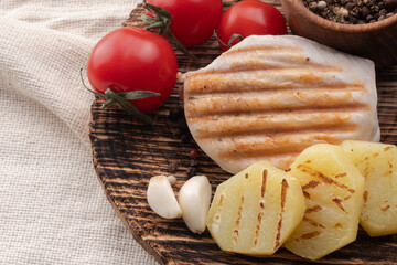 chicken with vegetables on a wooden board. meat with tomatoes and spices