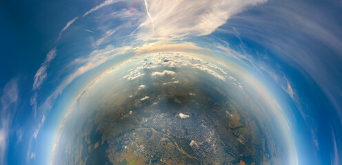 Aerial view from airplane window at high altitude of little planet distant city covered with layer...