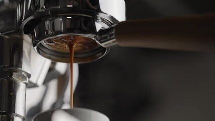 Slow motion pull espresso shot with bottomless portafilter on a professional coffee machine