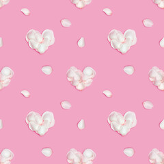 Shape Heart made of rose flower petals and white petals around on pink background. Minimal Valentines card for February 14th. Festive valentine day concept. Flat lay, top view, pastel colors.