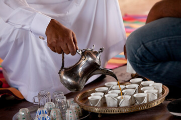 Pouring coffee into cups in a Bedouin tent
