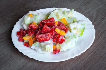 Frozen vegetables on a white plate - bell peppers, zucchini. Healthy food concept.