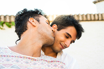 Boyfriend kissing his partner in the cheek. Young gay couple