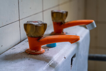 Closeup of an old pastic water tap in a derelict house