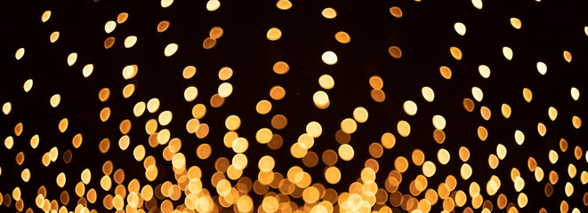 Defocused abstract background. Bokeh. Light from garlands on a black background.