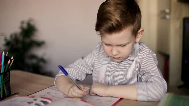 Russian boy does his homework. First grader
