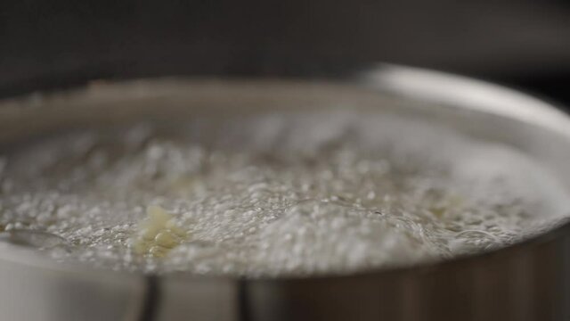 Slow motion farfalle pasta boiling in saucepan closeup