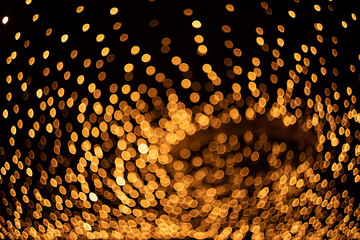 Defocused abstract background. Bokeh. Light from garlands on a black background.