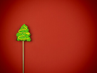 Gingerbread Christmas tree on red background. Holiday concept, minimalism