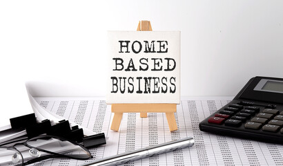 text Home Based Business on easel with office tools and paper.Top view. Business concept