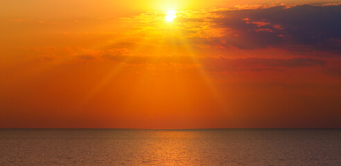 Obraz na płótnie Canvas A tropical beach and bright sunset. Wide photo.